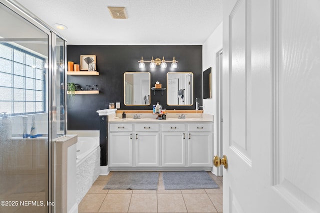 bathroom featuring vanity, separate shower and tub, tile patterned flooring, and a textured ceiling