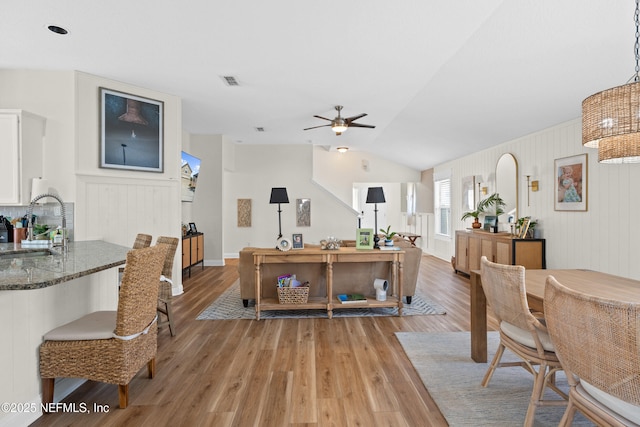 interior space with vaulted ceiling, sink, hardwood / wood-style floors, and ceiling fan