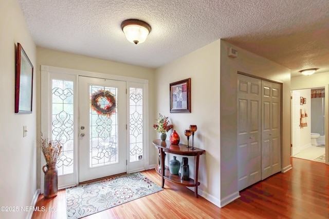 foyer entrance with hardwood / wood-style flooring and a textured ceiling