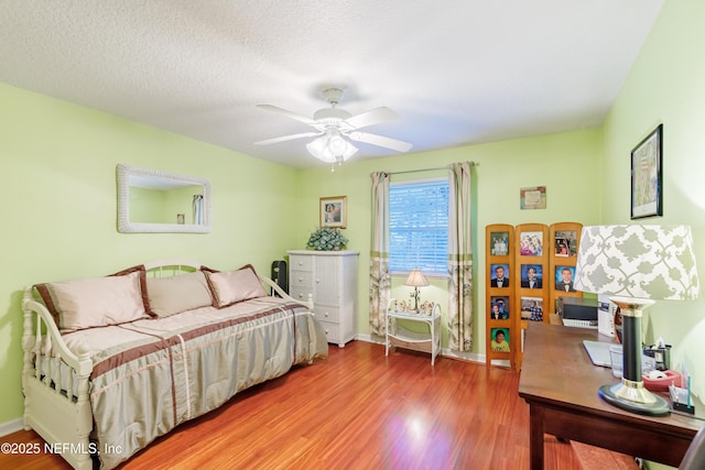 bedroom featuring hardwood / wood-style floors, a textured ceiling, and ceiling fan