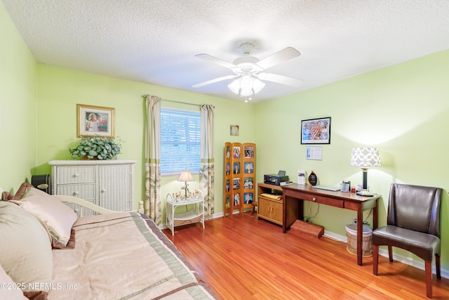 bedroom with ceiling fan, a textured ceiling, and light wood-type flooring