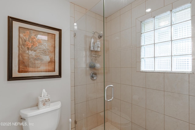 bathroom with a shower with door and toilet