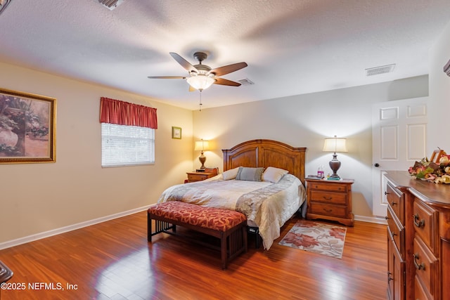 bedroom with ceiling fan, a textured ceiling, and light wood-type flooring