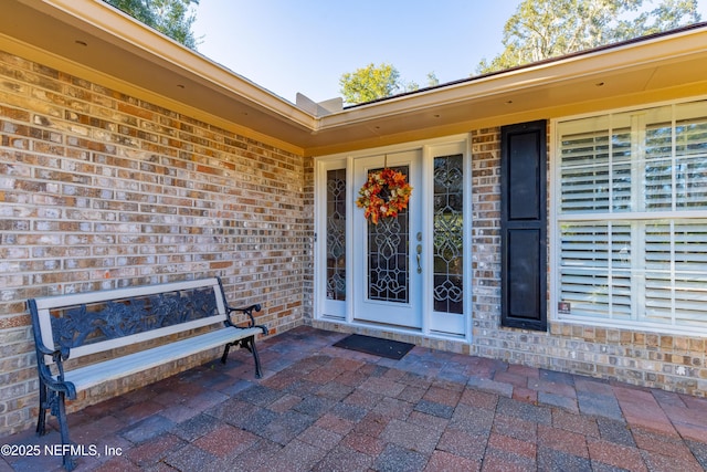 view of exterior entry with a patio area