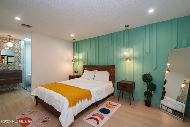 bedroom featuring a textured ceiling and light hardwood / wood-style floors