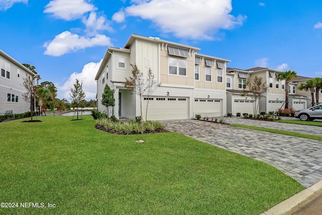 view of property with a garage and a front lawn