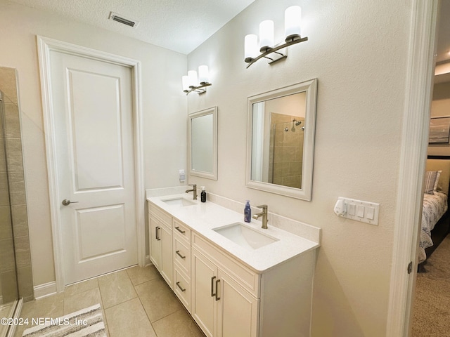 bathroom featuring tile patterned floors, vanity, and a textured ceiling