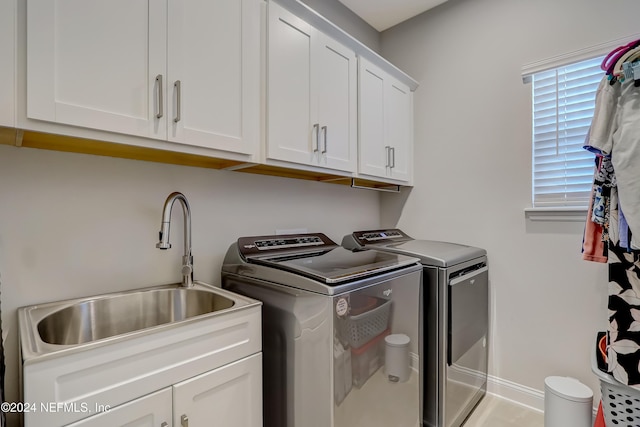 laundry room featuring cabinets, sink, and washing machine and clothes dryer