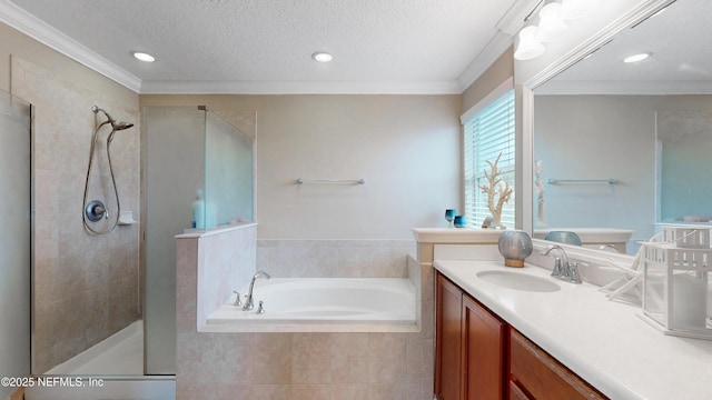 bathroom featuring a textured ceiling, vanity, ornamental molding, a shower stall, and a bath