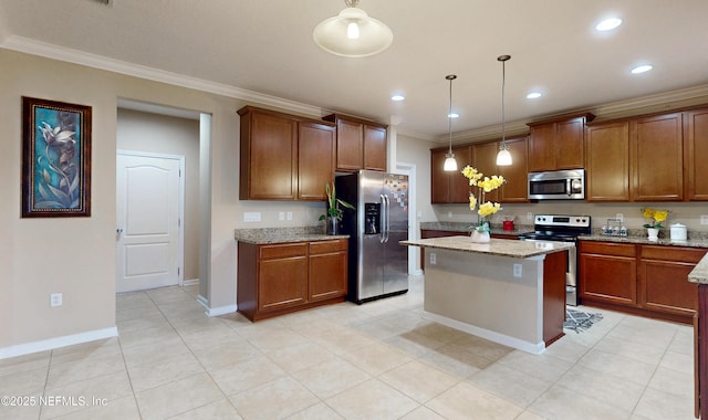 kitchen with appliances with stainless steel finishes, brown cabinets, light stone counters, a center island, and hanging light fixtures