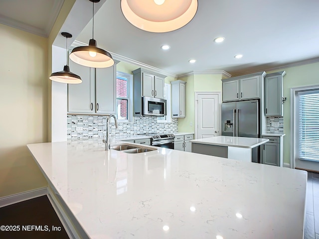 kitchen featuring gray cabinetry, stainless steel appliances, a sink, and pendant lighting