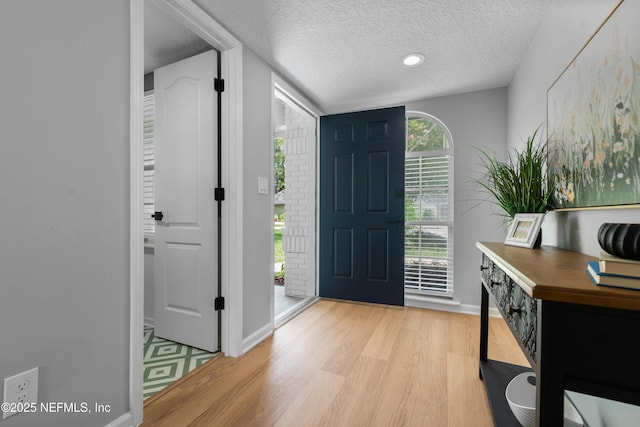 entrance foyer with light hardwood / wood-style floors and a textured ceiling