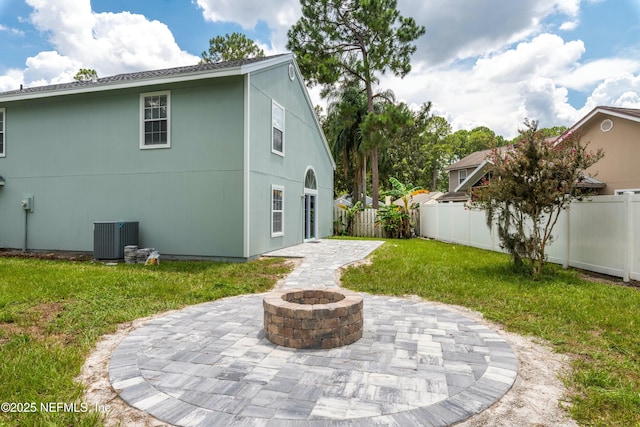 back of house with a yard, a patio area, and an outdoor fire pit