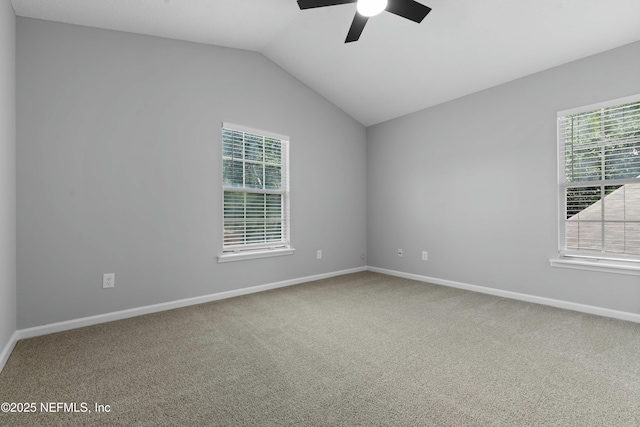 carpeted spare room featuring vaulted ceiling and ceiling fan