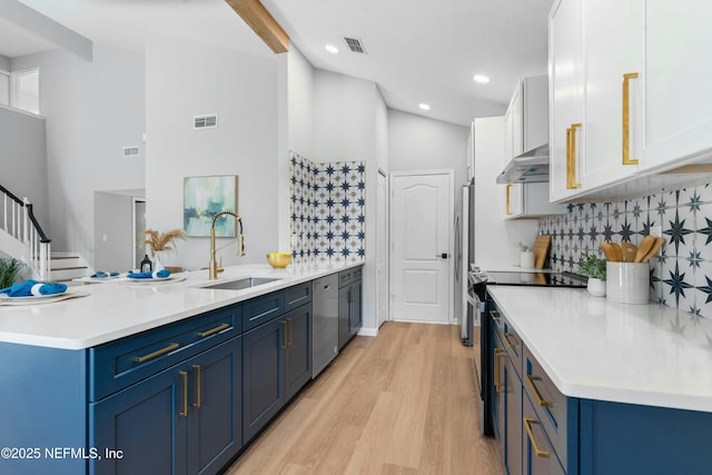 kitchen with sink, blue cabinetry, stainless steel appliances, white cabinets, and light wood-type flooring