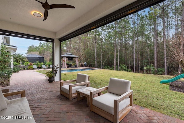 view of patio with a gazebo, an outdoor pool, a playground, and fence