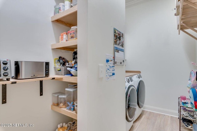 laundry room with baseboards, independent washer and dryer, wood finished floors, and laundry area