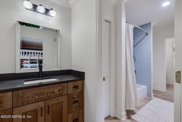 bathroom featuring wood finished floors, shower / bath combo with shower curtain, vanity, and ornamental molding