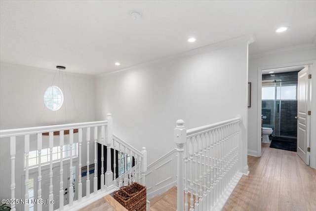 hall featuring ornamental molding, an upstairs landing, recessed lighting, light wood-style flooring, and wainscoting