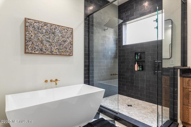 full bath featuring a sink, a freestanding tub, and a shower stall