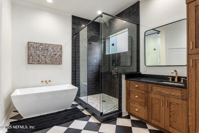 bathroom featuring tile patterned floors, a stall shower, crown molding, a freestanding bath, and vanity