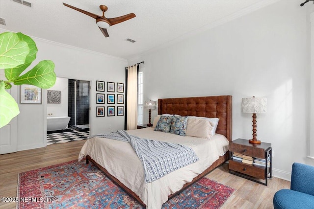 bedroom featuring visible vents, baseboards, wood finished floors, and ornamental molding