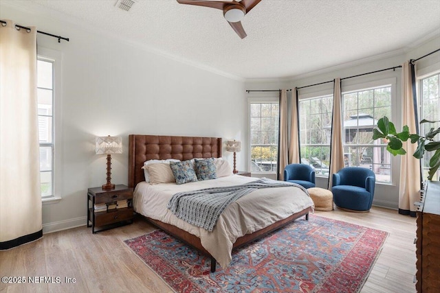 bedroom featuring visible vents, a textured ceiling, and wood finished floors
