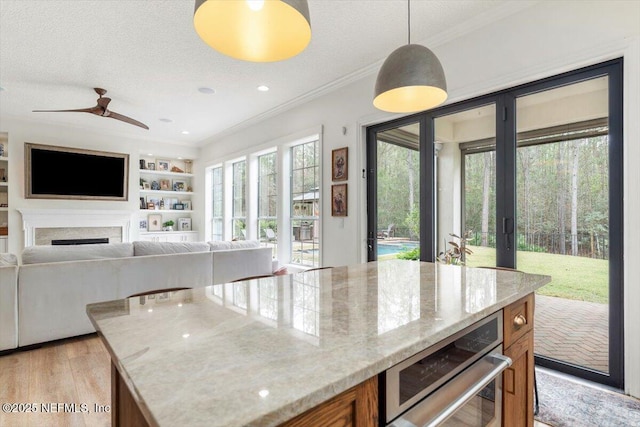 kitchen with built in shelves, a textured ceiling, ornamental molding, and brown cabinetry