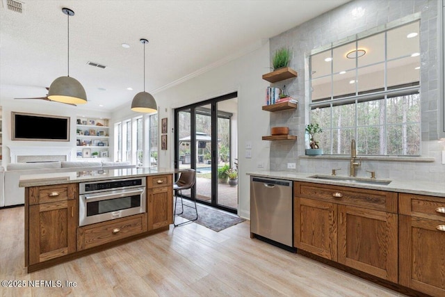 kitchen with brown cabinetry, visible vents, appliances with stainless steel finishes, and a sink