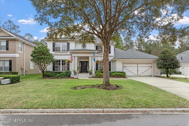 view of front of home with a front lawn, concrete driveway, roof with shingles, stucco siding, and a garage