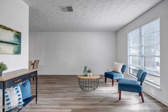 sitting room featuring hardwood / wood-style floors and a textured ceiling