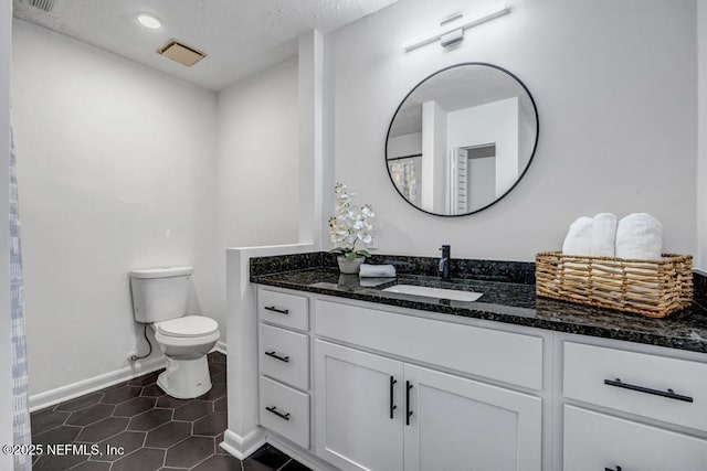 bathroom with tile patterned flooring, vanity, and toilet