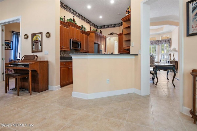 kitchen featuring backsplash, light tile patterned floors, kitchen peninsula, stainless steel appliances, and a textured ceiling