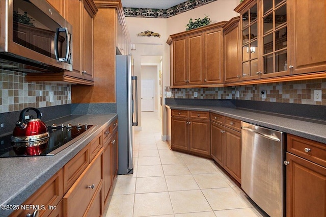 kitchen with stainless steel appliances, tasteful backsplash, and light tile patterned floors