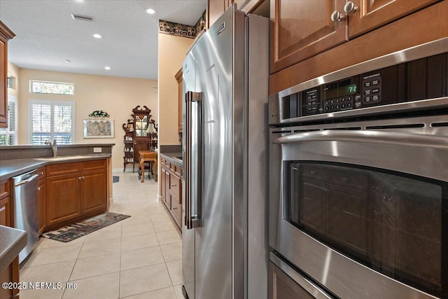 kitchen with stainless steel appliances, sink, and light tile patterned floors