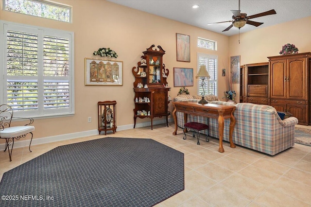 tiled living room featuring ceiling fan and a textured ceiling