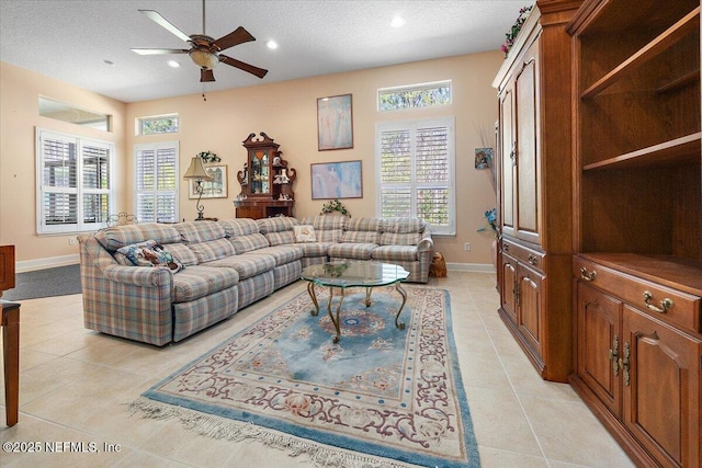 tiled living room featuring ceiling fan, plenty of natural light, and a textured ceiling