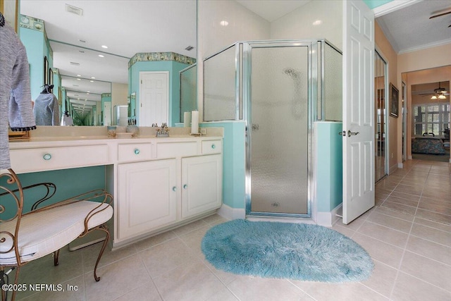 bathroom featuring a shower with door, vanity, tile patterned floors, and ceiling fan