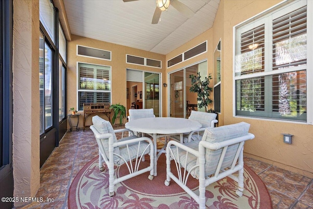 sunroom / solarium with a healthy amount of sunlight and ceiling fan