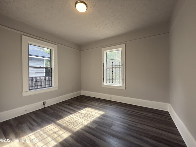 6624 Avalon St, Jacksonville, FL 32208 - empty room with baseboards, dark wood-style flooring, and a textured ceiling
