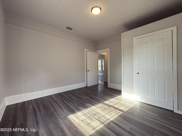 6624 Avalon St, Jacksonville, FL 32208 - unfurnished bedroom with dark wood-style floors, visible vents, baseboards, and a textured ceiling