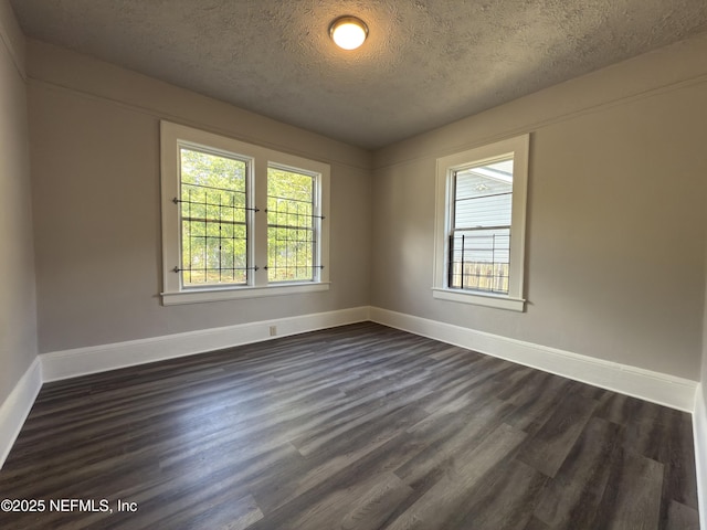 6624 Avalon St, Jacksonville, FL 32208 - empty room with dark wood-style floors, baseboards, and a textured ceiling