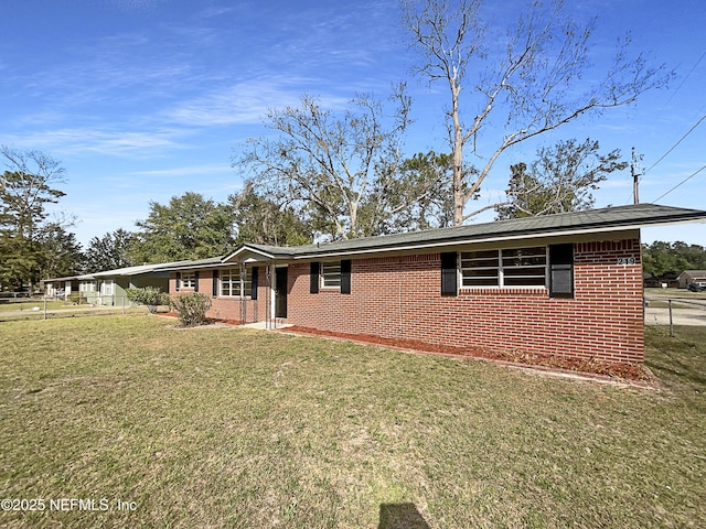 single story home featuring brick siding, a front yard, and fence