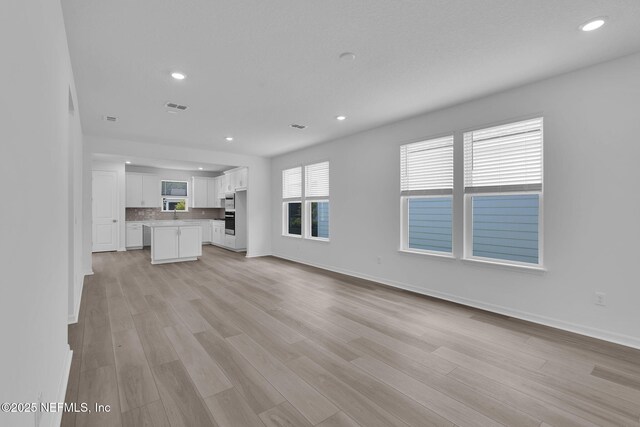 232 Fairlake Cir, Saint Augustine, FL 32092 - unfurnished living room with recessed lighting and light wood-style floors