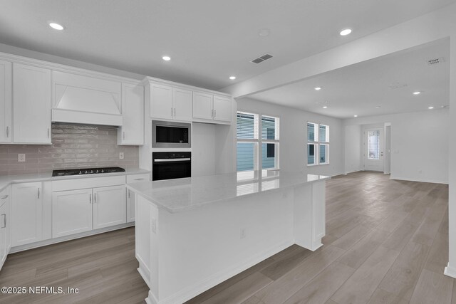 232 Fairlake Cir, Saint Augustine, FL 32092 - kitchen featuring black appliances, premium range hood, white cabinetry, and recessed lighting