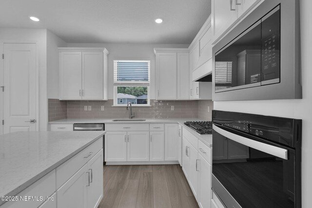 232 Fairlake Cir, Saint Augustine, FL 32092 - kitchen with appliances with stainless steel finishes, white cabinetry, light wood-style flooring, tasteful backsplash, and recessed lighting