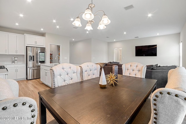 dining area with visible vents, recessed lighting, a notable chandelier, and light wood-type flooring