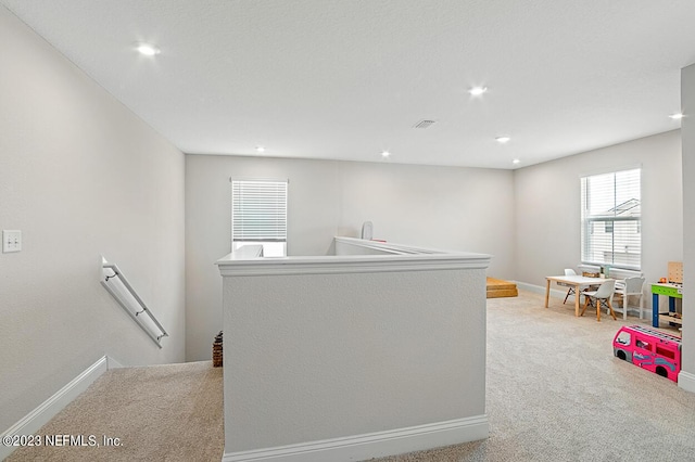 interior space featuring baseboards, recessed lighting, visible vents, and light carpet