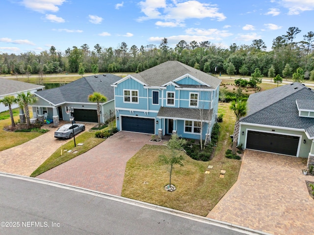 view of front of house featuring decorative driveway, a shingled roof, board and batten siding, a garage, and a front lawn