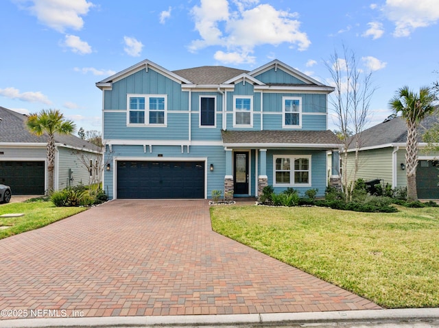 view of front facade featuring an attached garage, decorative driveway, a front lawn, and board and batten siding